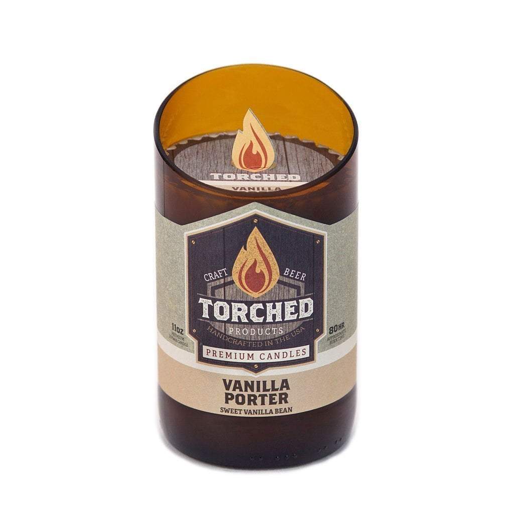 An 11 oz. beer bottle with the top cut off at a 20 degree angle.  The bottle has been filled with wax and is being sold as a candle.  The label shows an illustration of a flame and says 'Torched, craft beer premium candles.  Vanilla Porter, Sweet Vanilla Bean'
